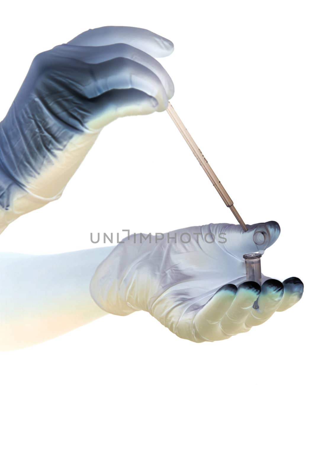 Shaded hands in gloves hold pipette and tube