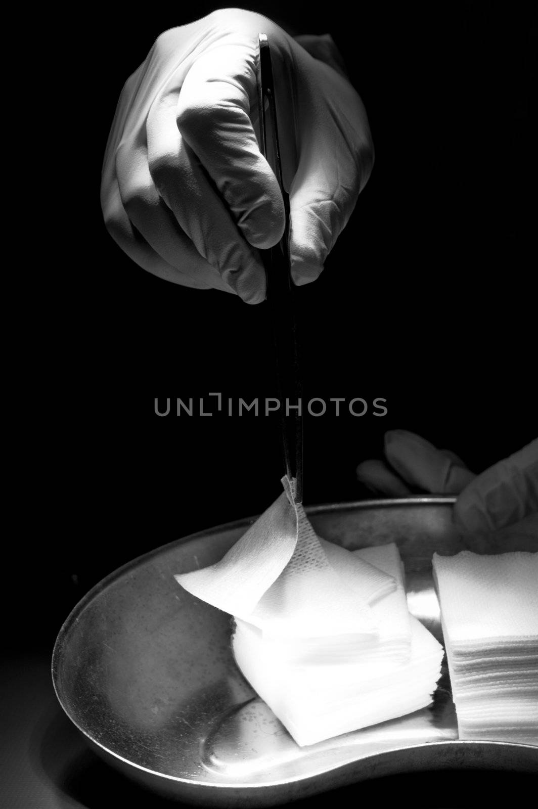 Doctor trying catch white swab by steel tweezers