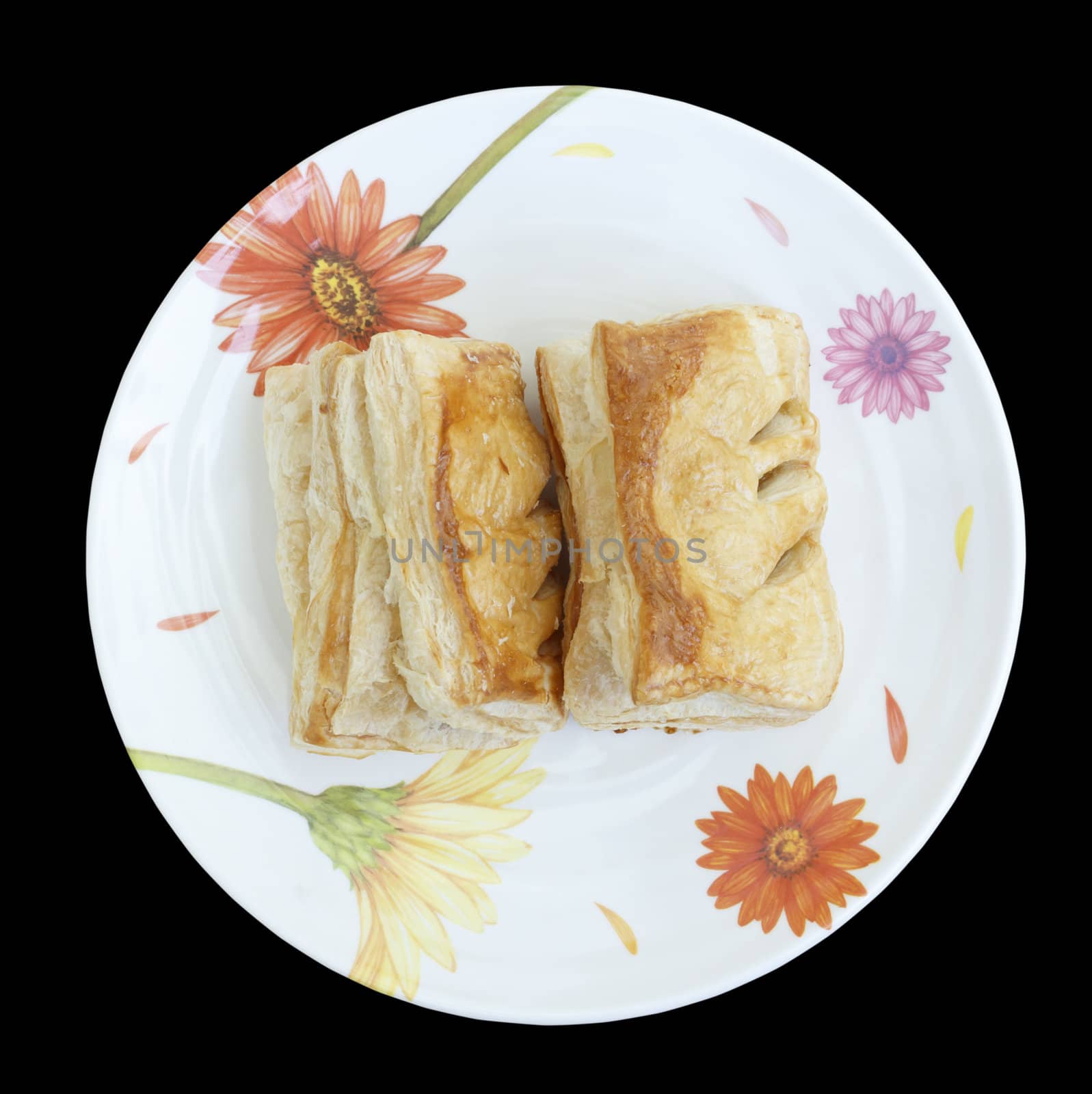 Stuffed puff pastry on plate isolated on black background