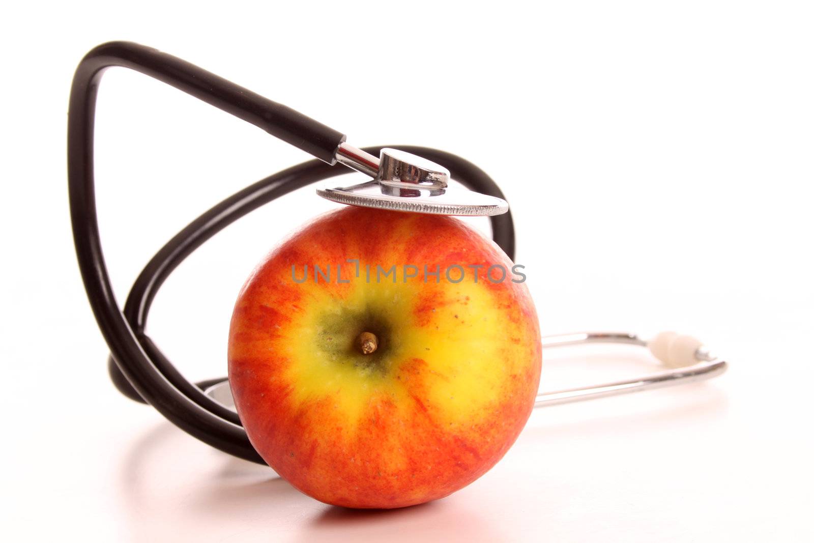 An apple being investigated bij a stethoscope