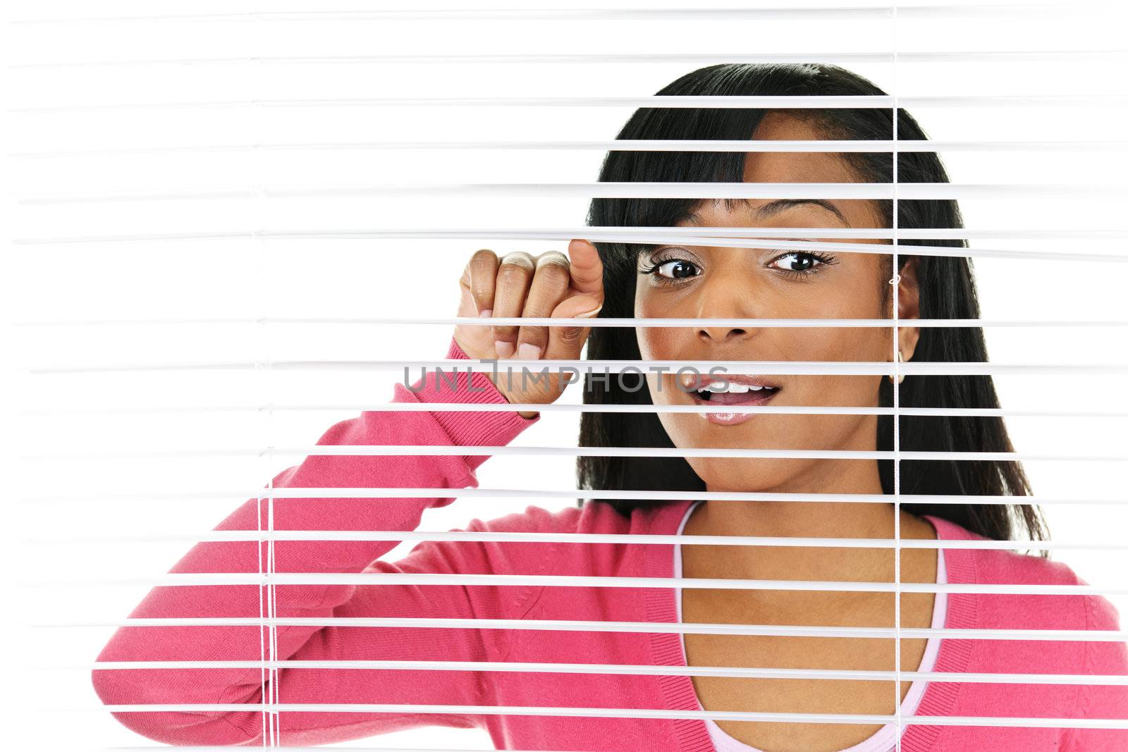 Young black woman looking through horizontal venetian blinds