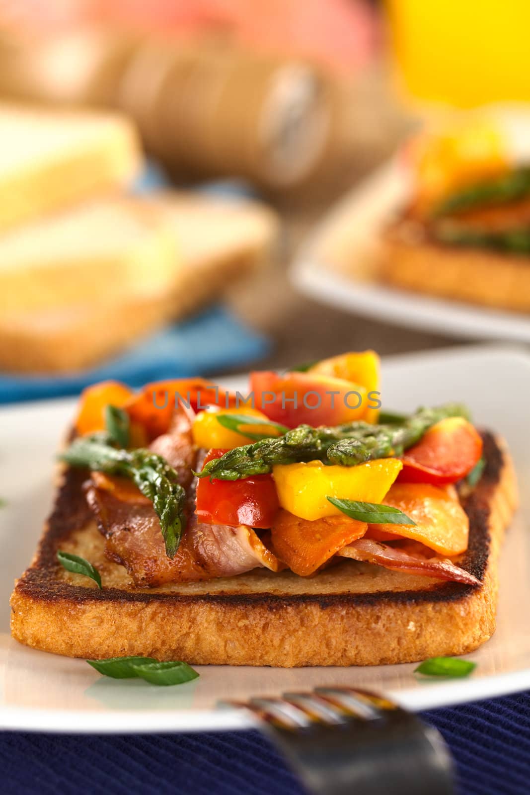 Baked asparagus, mango, tomato, carrot and bacon sandwich on wholewheat toast bread (Selective Focus, Focus on the asparagus tips in the front)