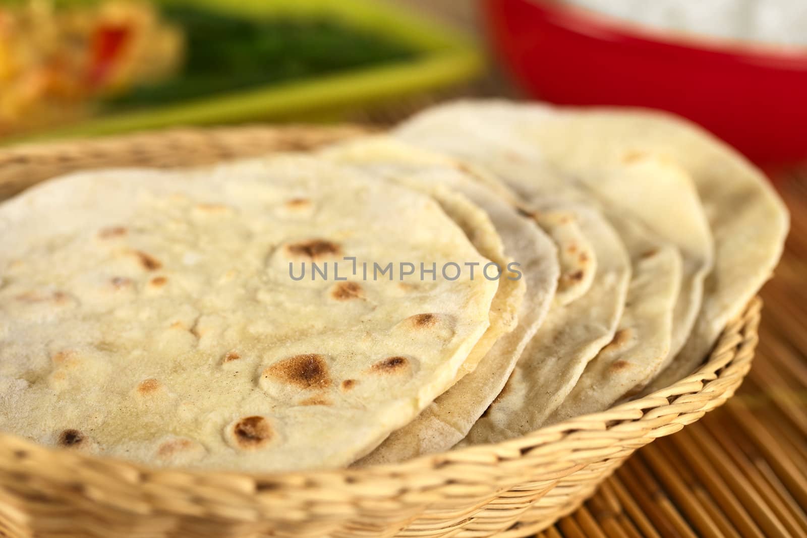 Indian flatbread called chapati in basket (Selective Focus, Focus on the big brown spot on the front of the first chapati)