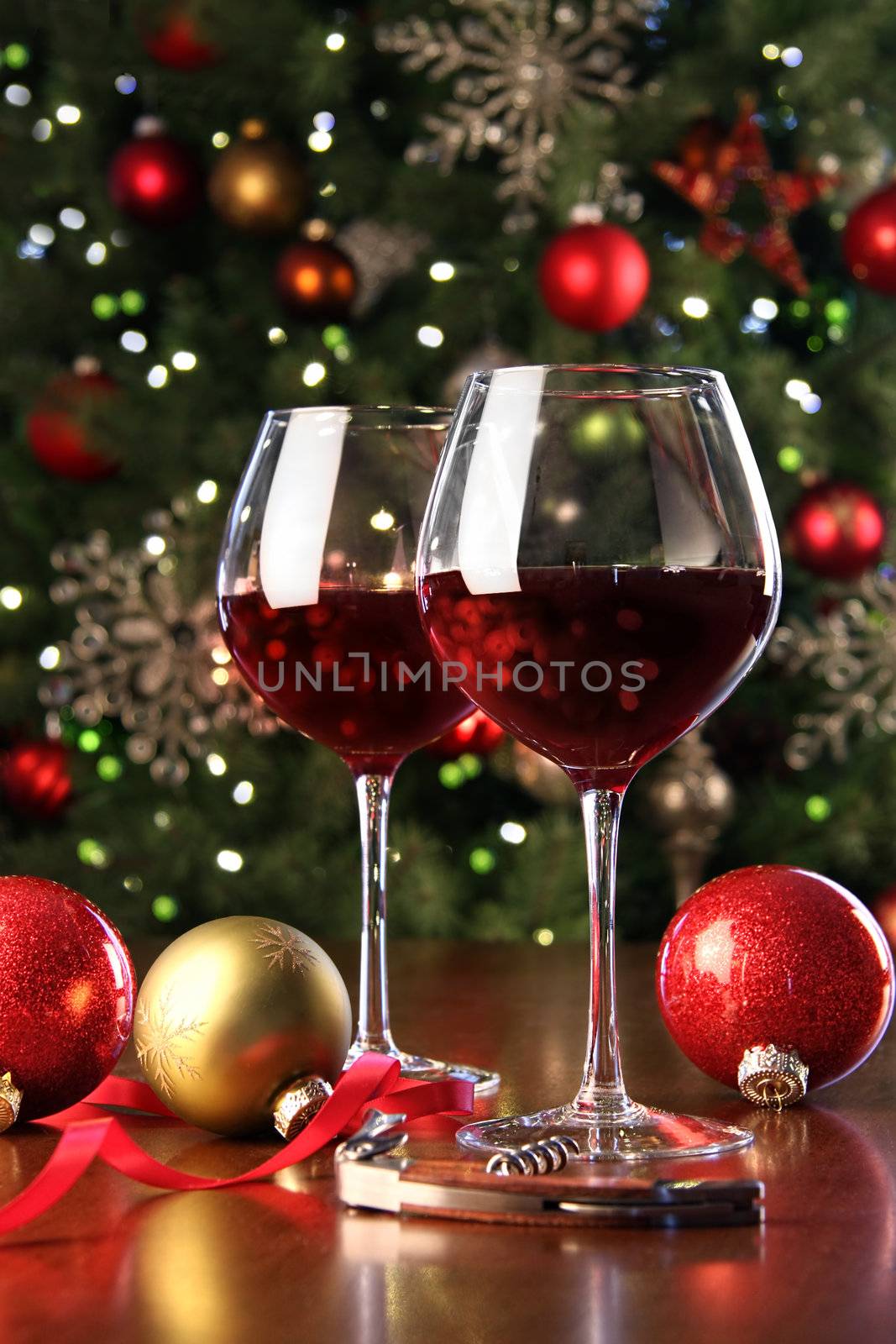 Glasses of red wine in front of Christmas tree for the holidays