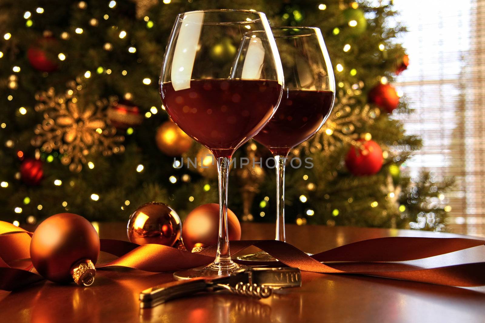 Red wine on table Christmas tree in background