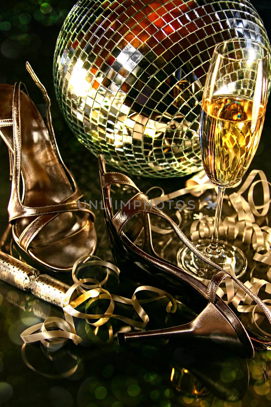 Silver party shoes on floor with champagne glass for New Year's Eve