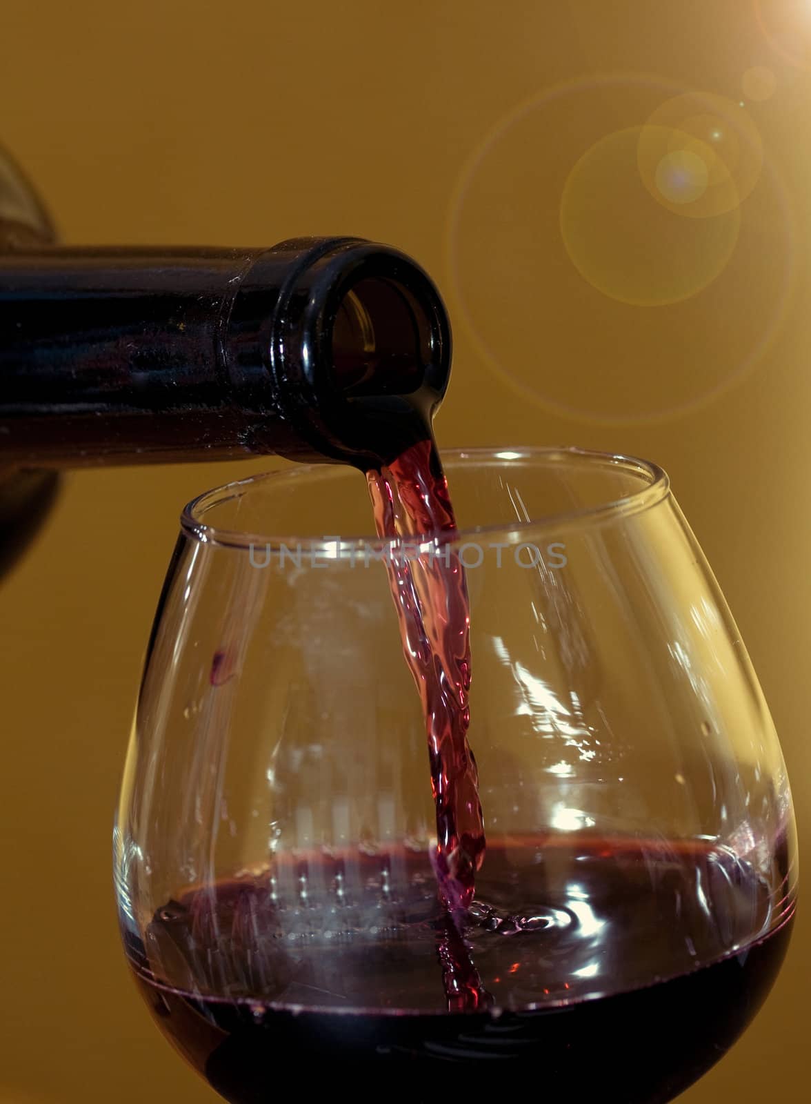 red wine pouring into wine glass in warm colors