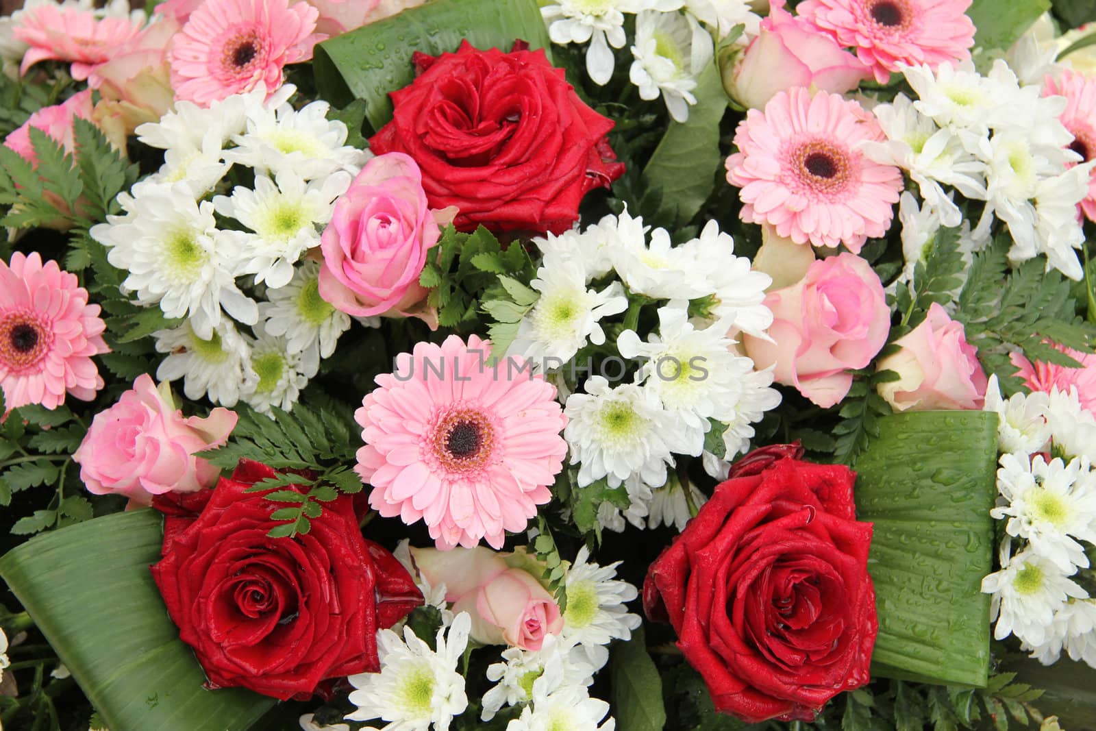 Red roses and pink gerberas in a mixed wedding centerpiece