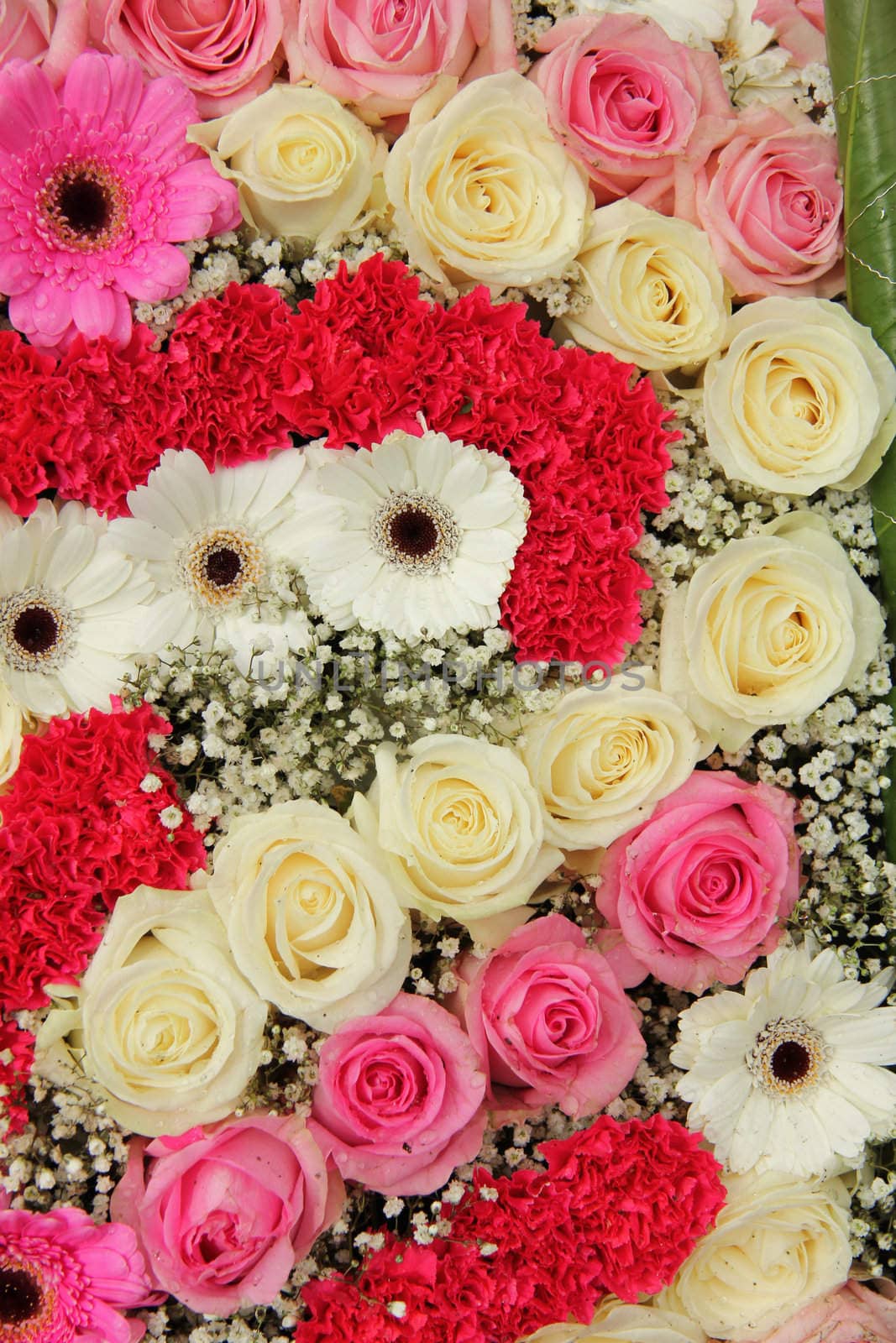 pink and white roses, together with carnations and gerberas in a wedding centerpiece