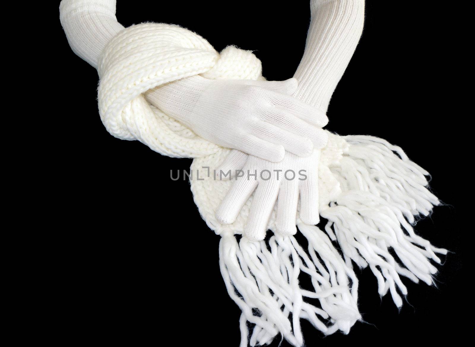 Two hands in gloves and scarf on black bacground