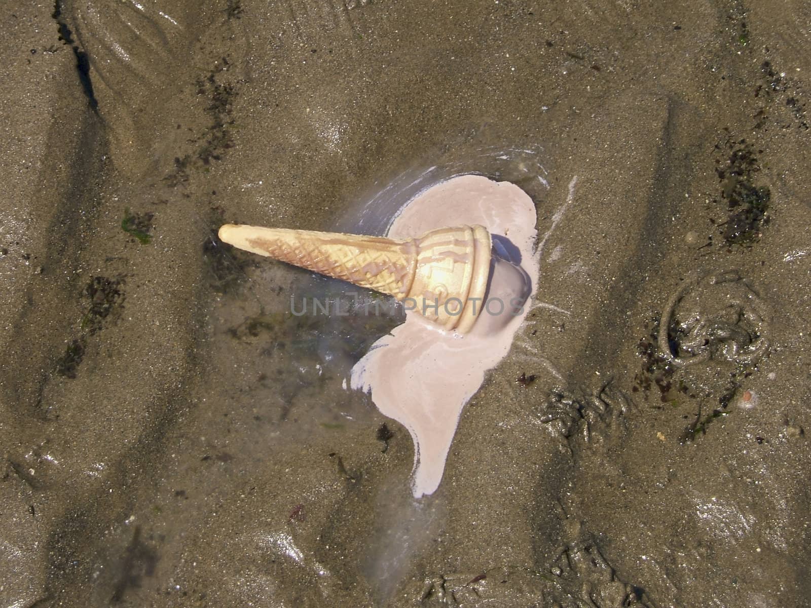 A pink ice cream dropped on the beach