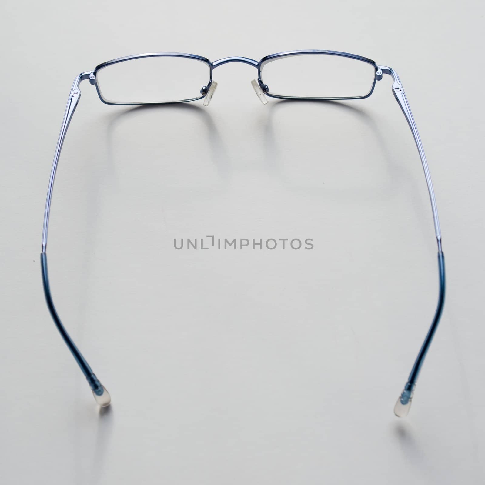 Stylish glasses in a blue frame on a grey background