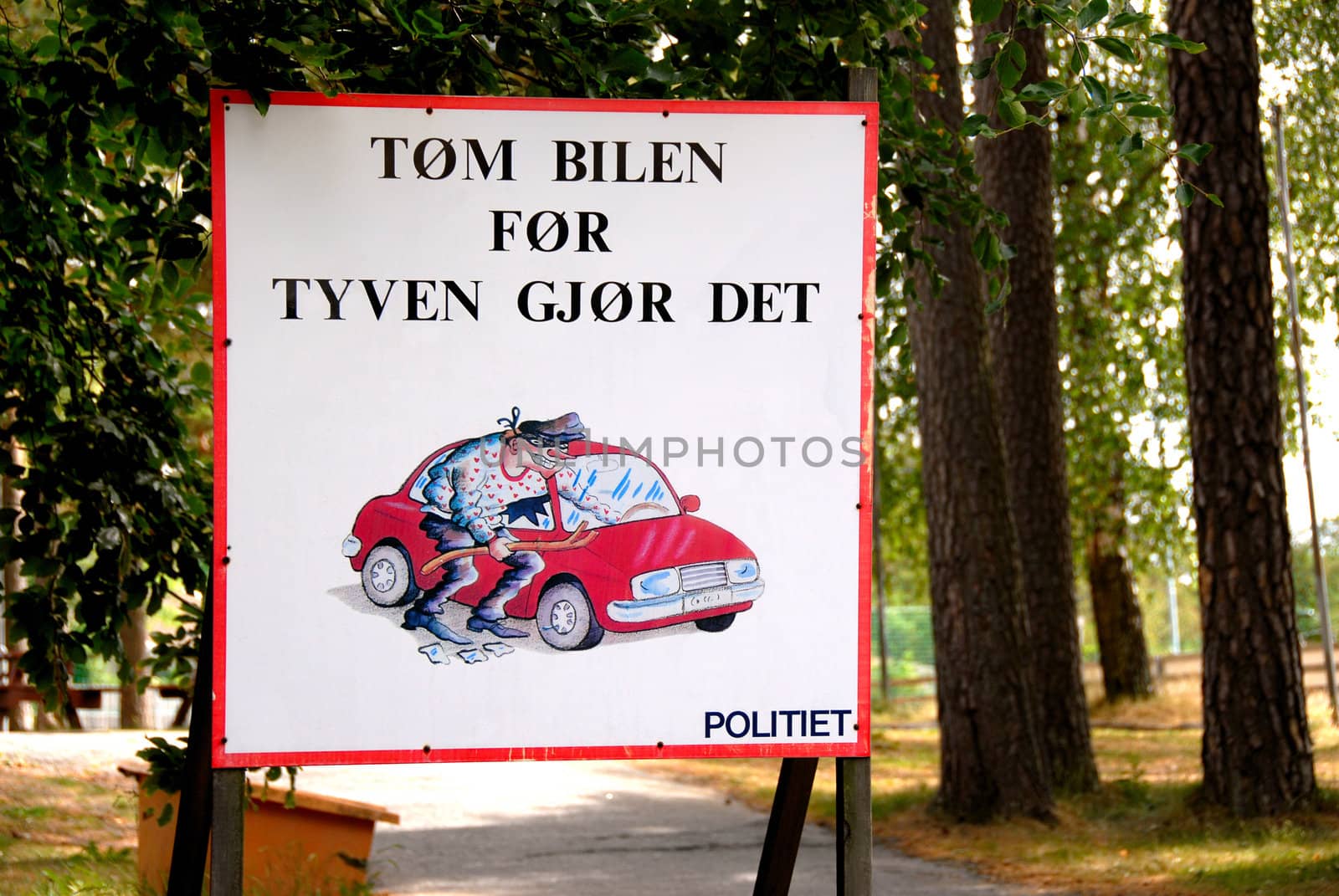 Norwegian sign with txt: Empty your car before the theaf do it. Norway 2008. Selectiv focus.