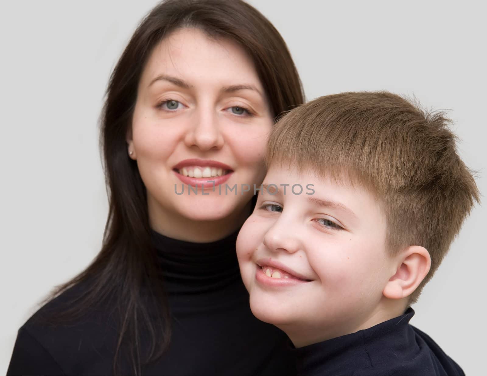 Smiling family. Mum and the son on a grey background.