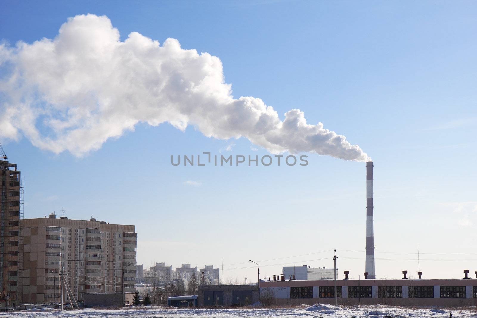 Smoking pipes of thermal power plant against blue sky
