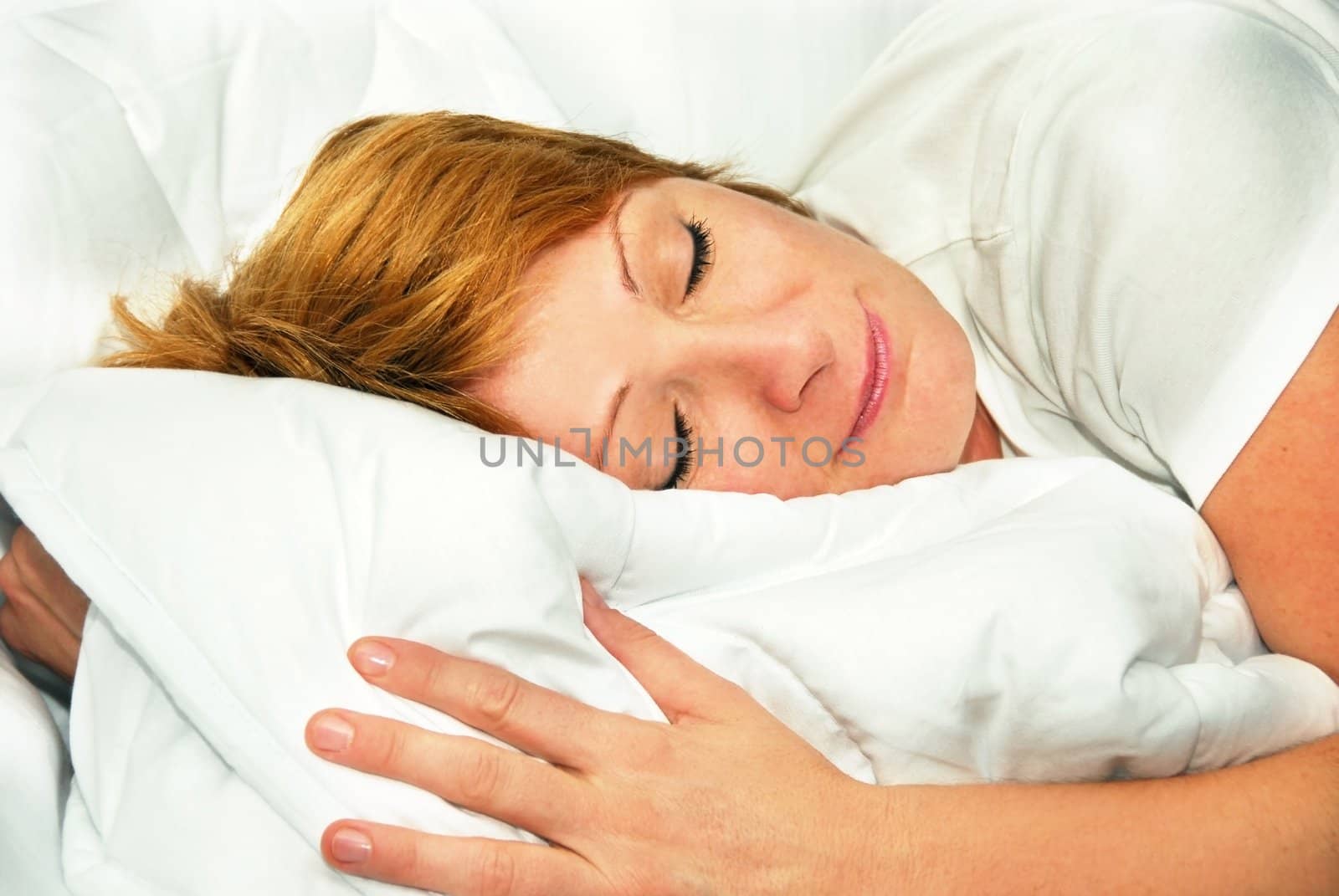 happy sleeping caucasian woman portrait lying on duvet indoors