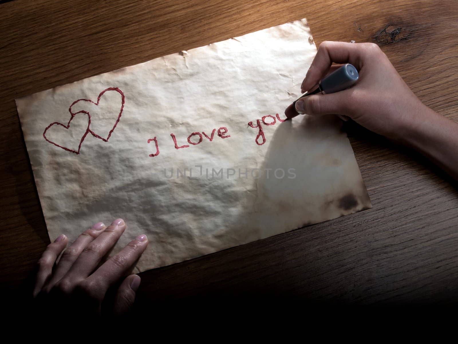 Girl writing a valentine to his beloved lipstick on the old paper