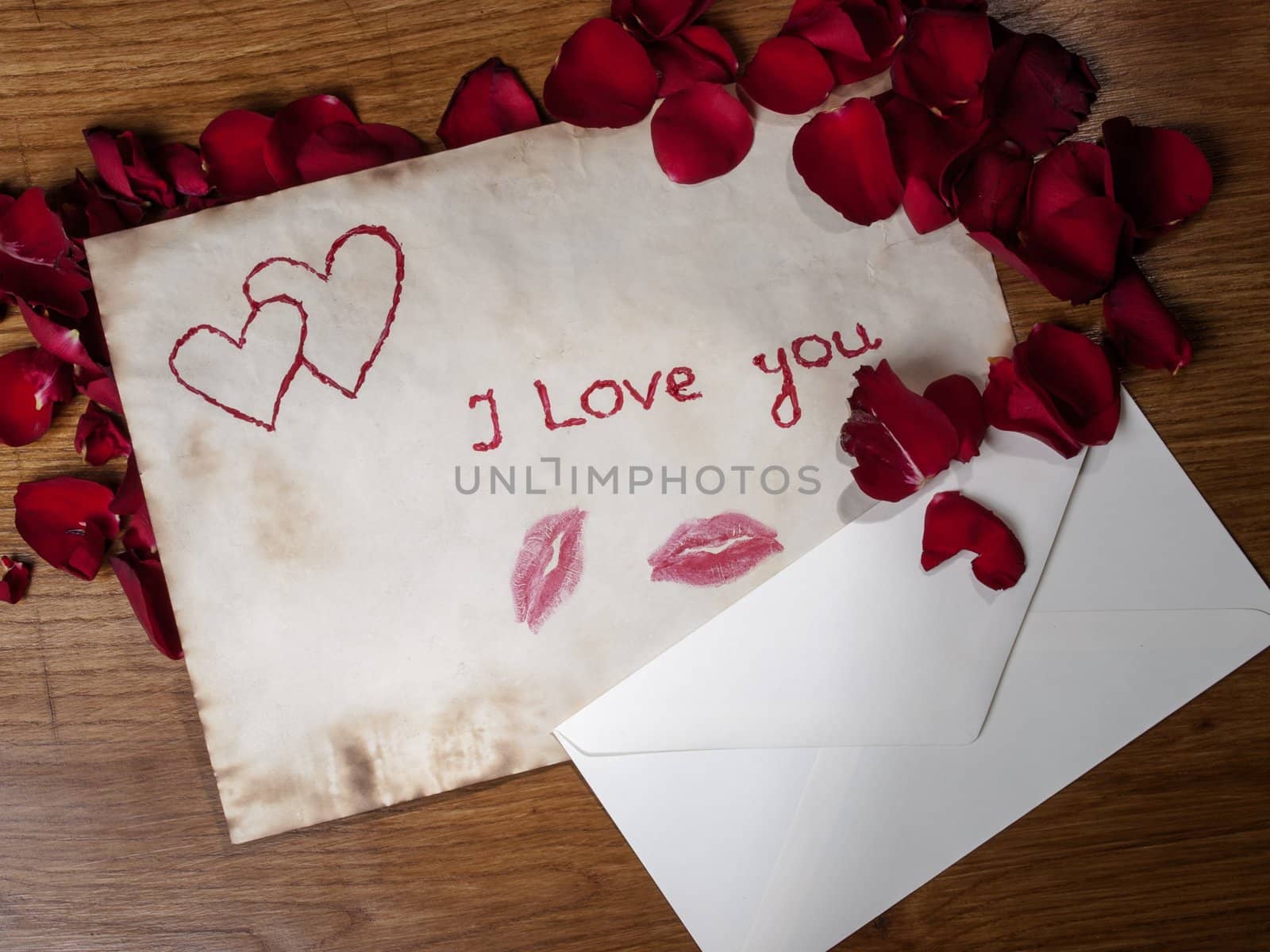composition of old valentines cards and envelopes with scattered rose petals on the wooden table