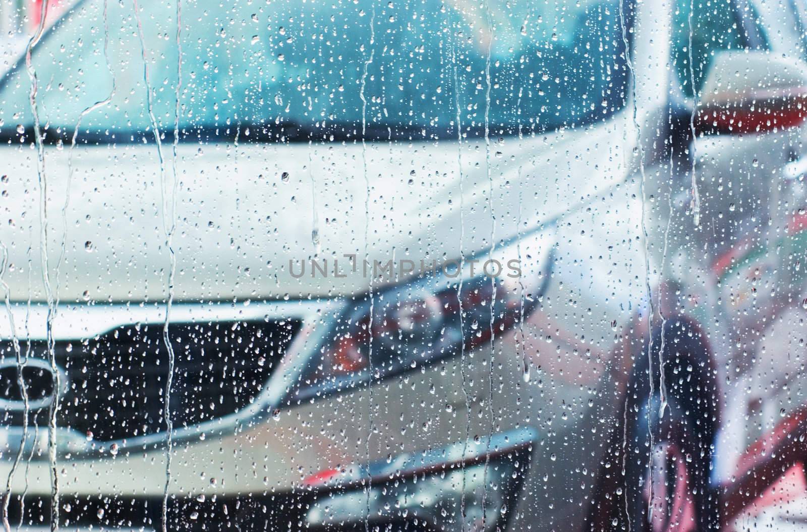 A car through the glass with rain drops