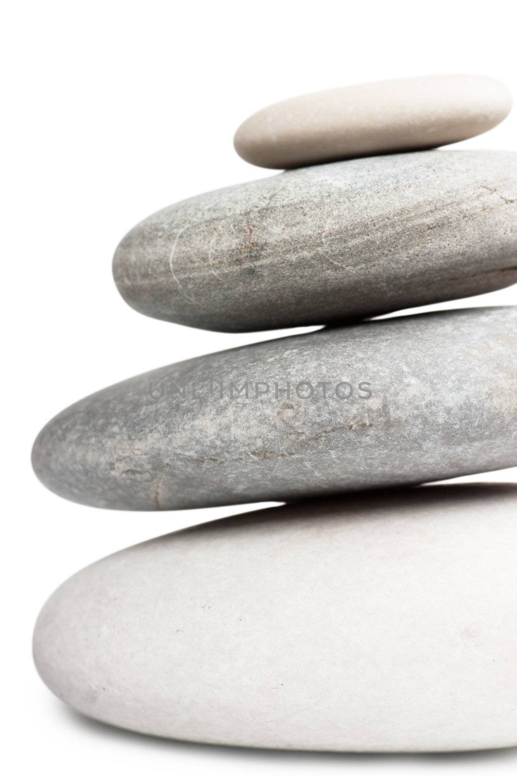 Stack of four round stones isolated over white background