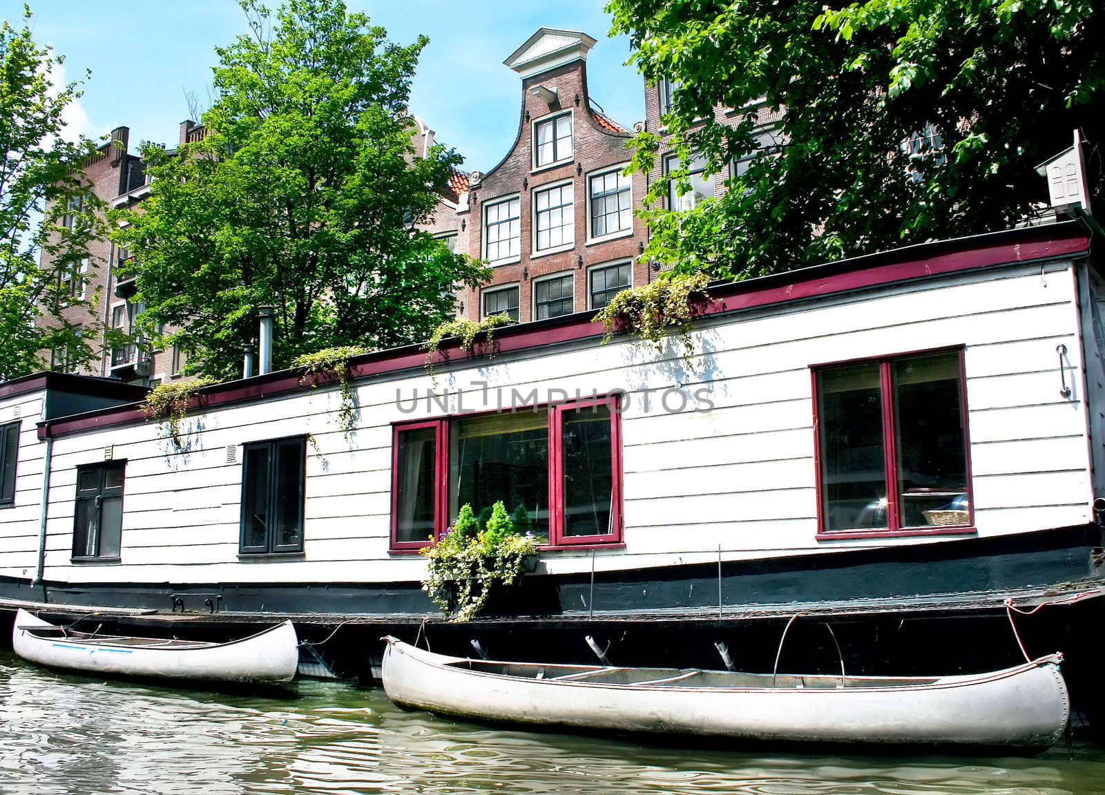 Floating house with boats in Amsterdam