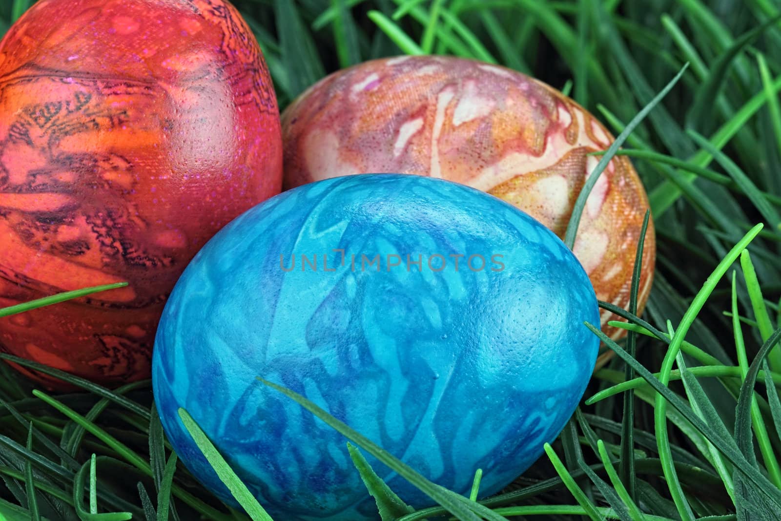 Three beautiful Easter eggs lying in the grass. Shallow depth of field.
