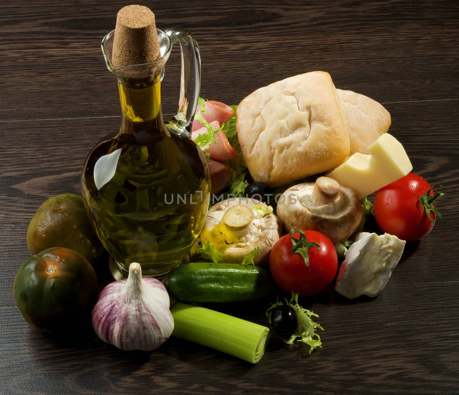 Still Life of Provence Snacks with Vegetables, Hamon, Ciabatta, Cheese and Olive Oil closeup on Dark Wood background