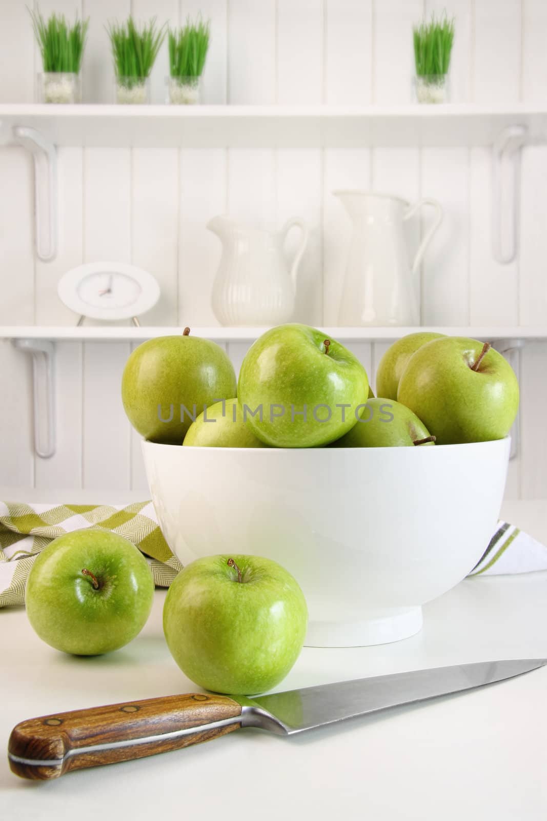 Green apples in bowl on table in kitchen
