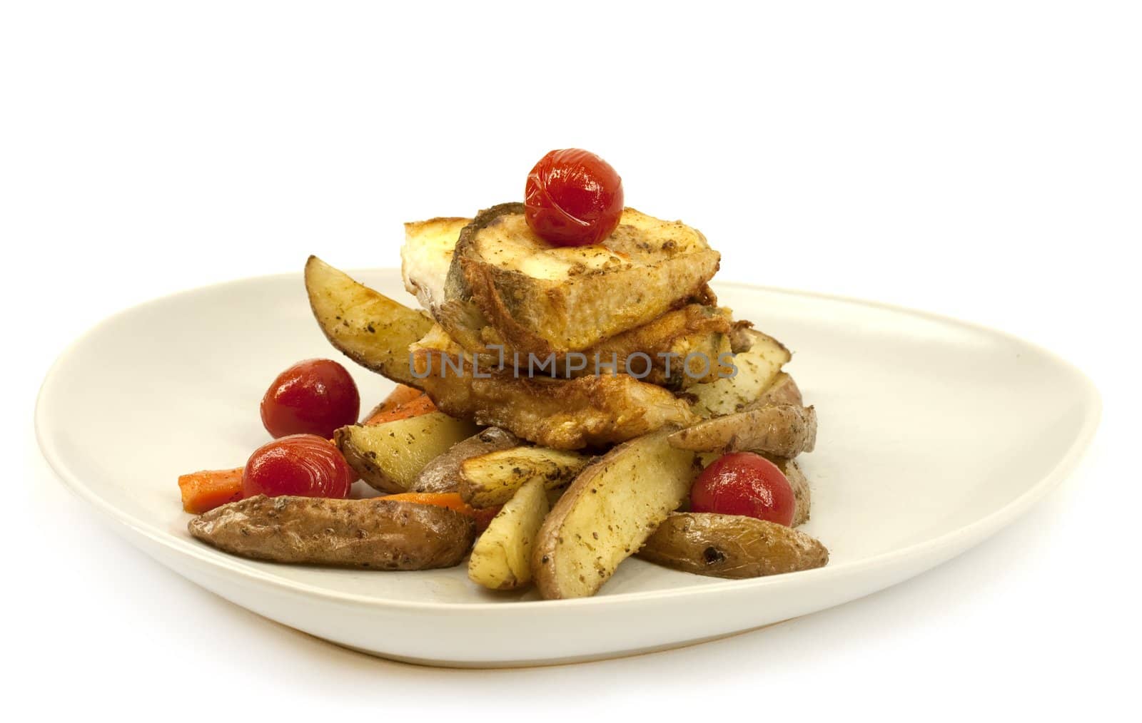 Fried haddock, carrots, tomatoes and potatoes