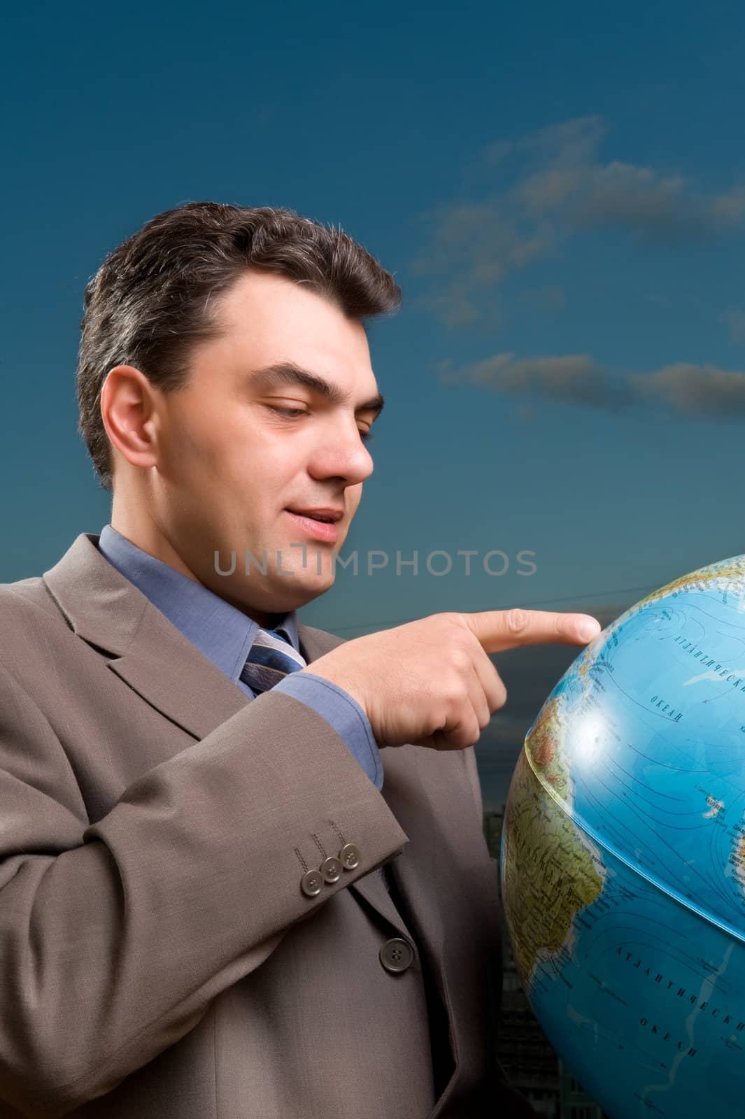 man in a suit against the evening sky with globe