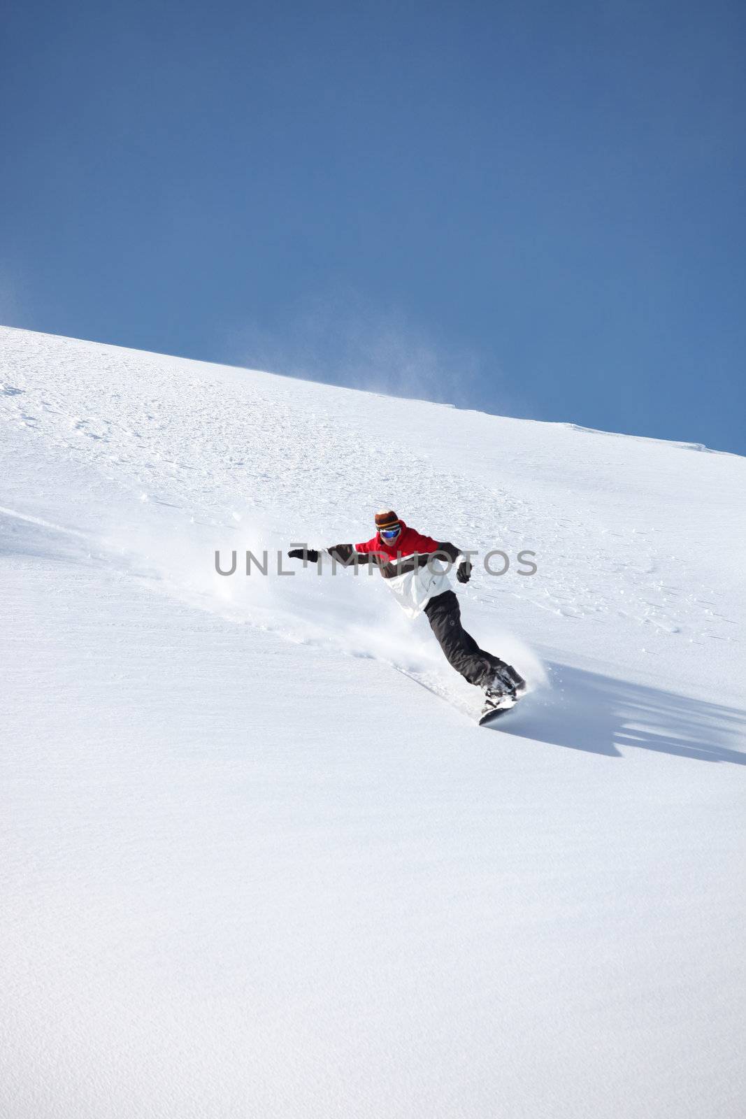 Man snowboarding down hill by phovoir