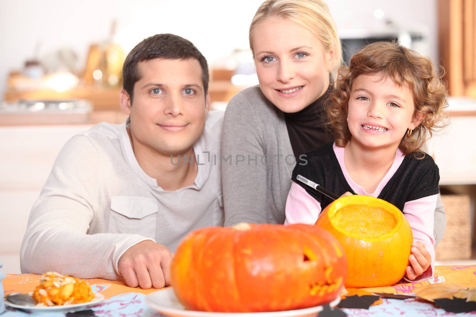 Family carving pumpkins together by phovoir