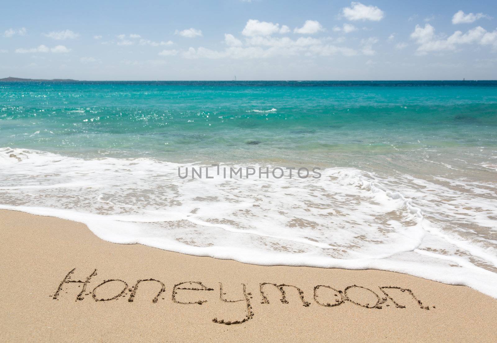 Honeymoon words written into sand on beach by sea in St Thomas