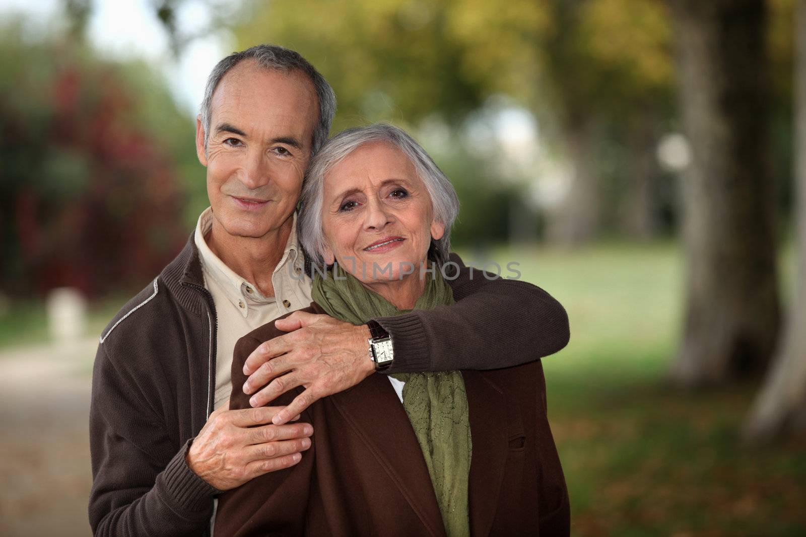 Old couple walking through park