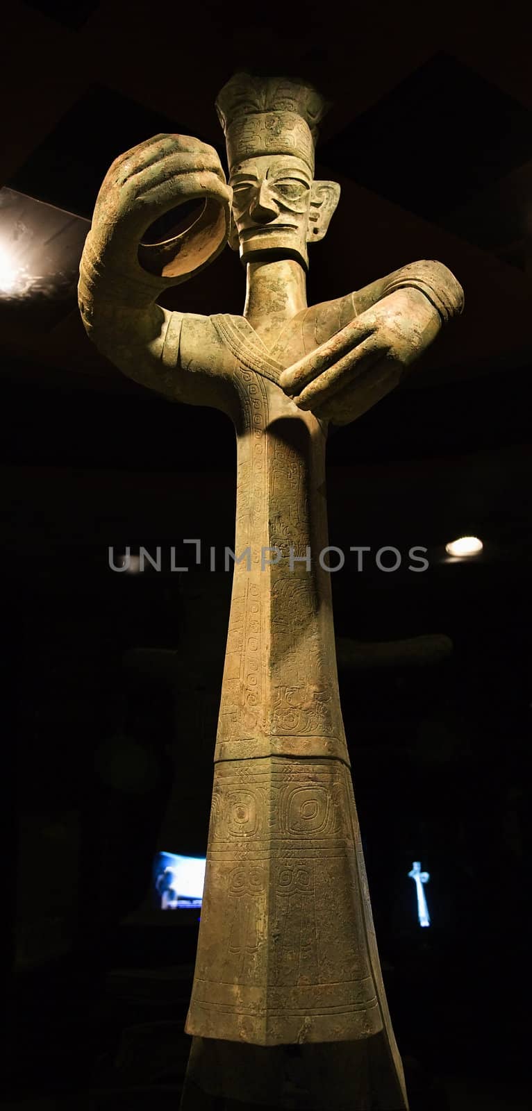 Tall Three Thousand Year Old Bronze Statue Sanxingdui Three Star Mound Museum Guanghan Chengdu Sichuan China This tall statue was discovered in a pit with elephant tusks.  The statues have been carbon dated to the 11th-12th Century BCE
