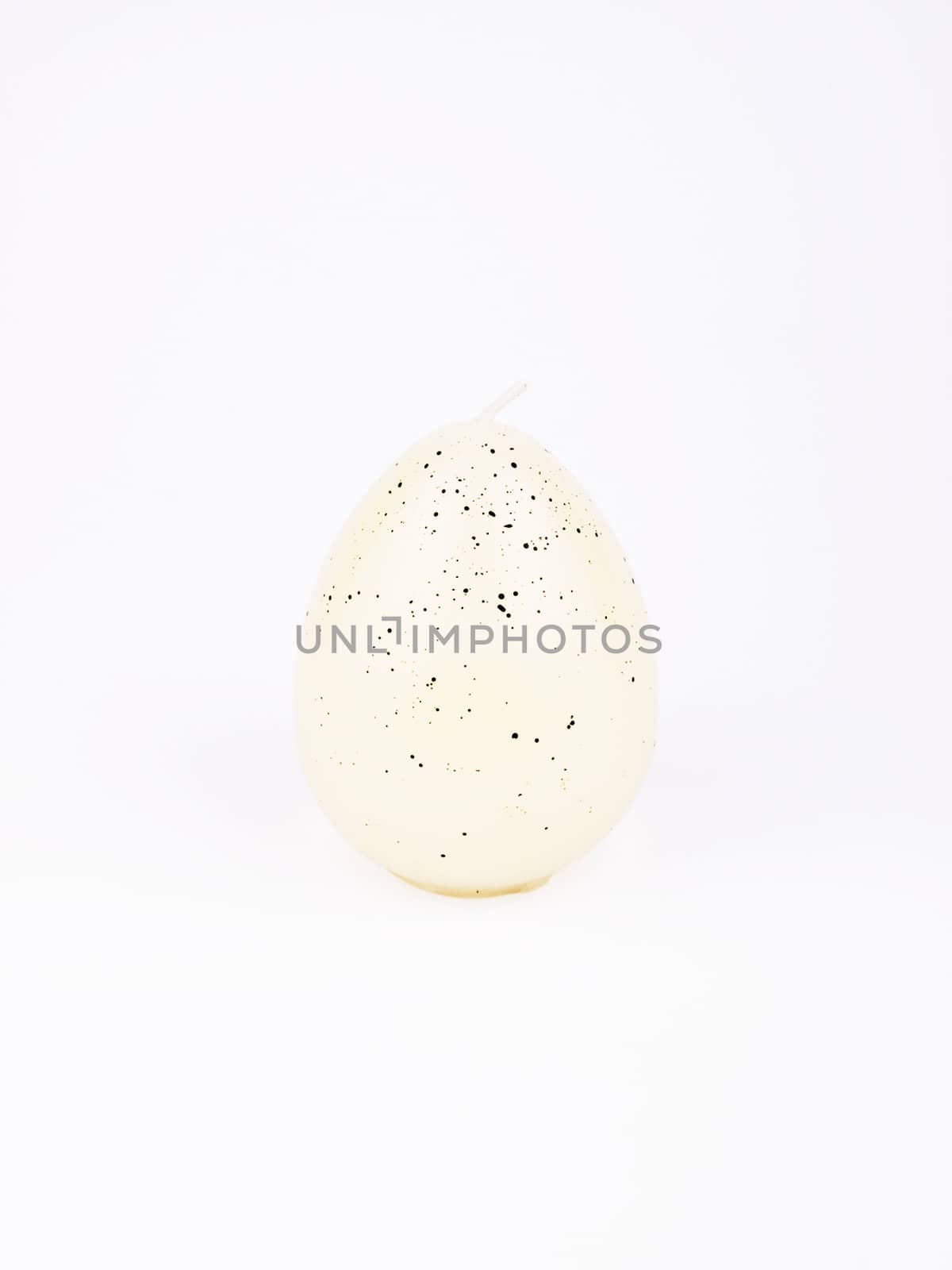 White candle formed in egg on white background