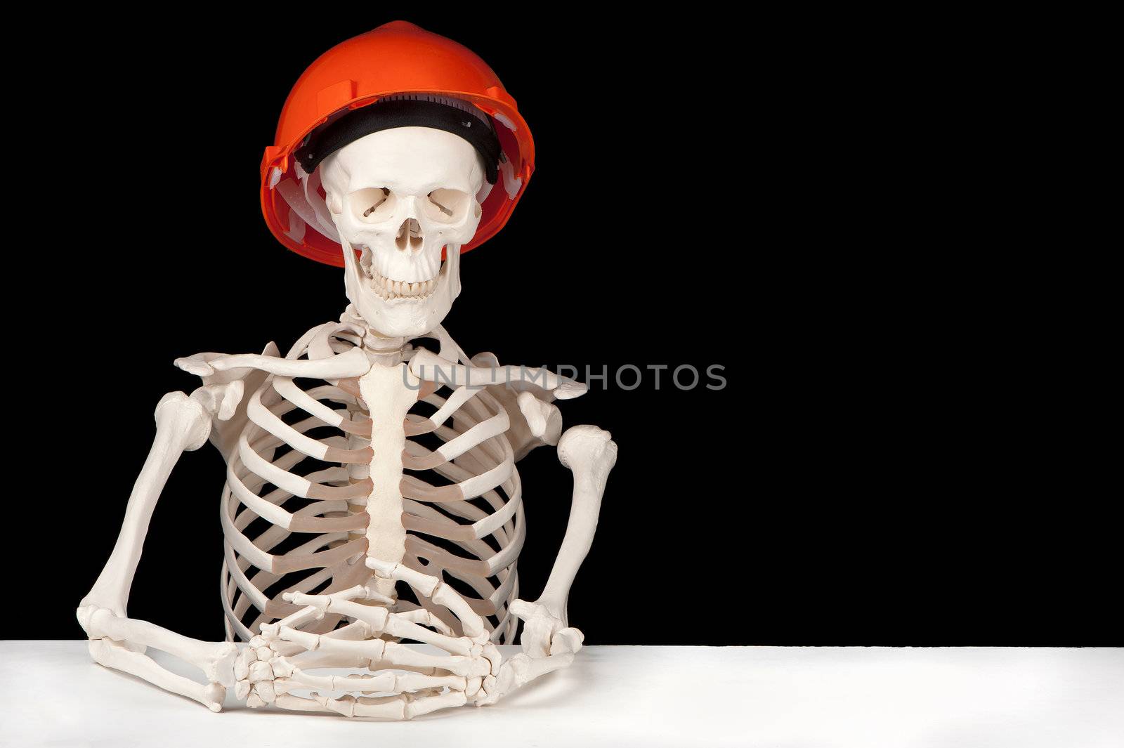 A skeleton with hard hat symbolizes death to the building industry.