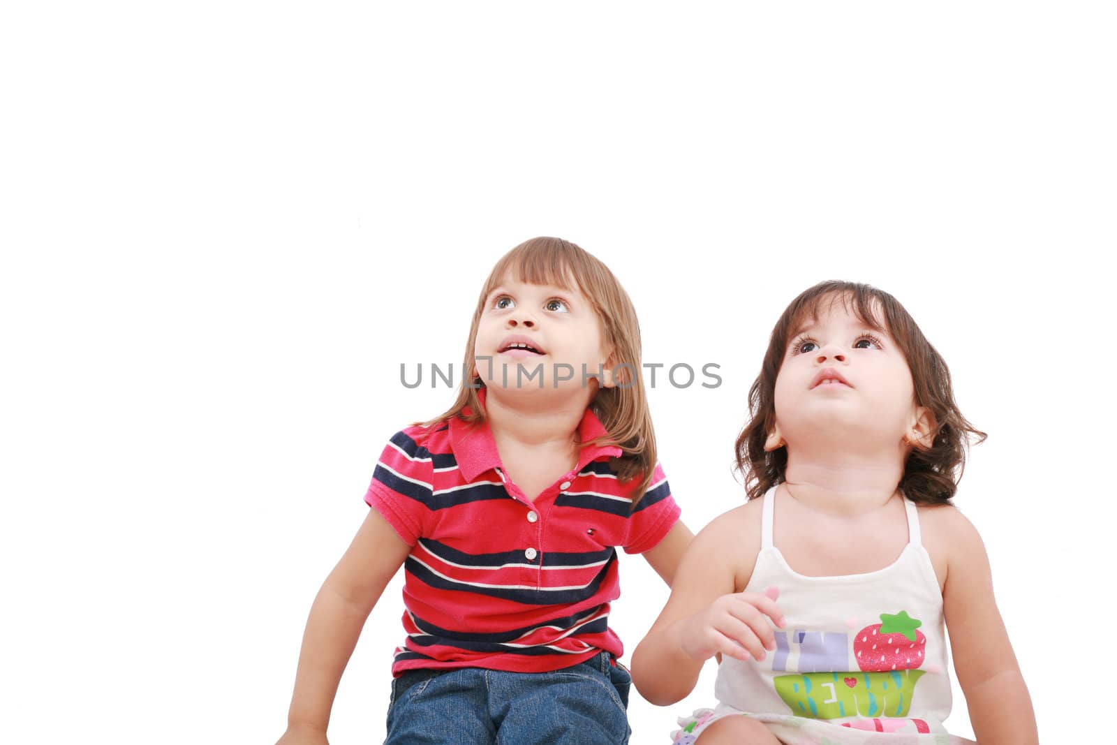 Two little girl looking up, two and four years old, isolated on white background