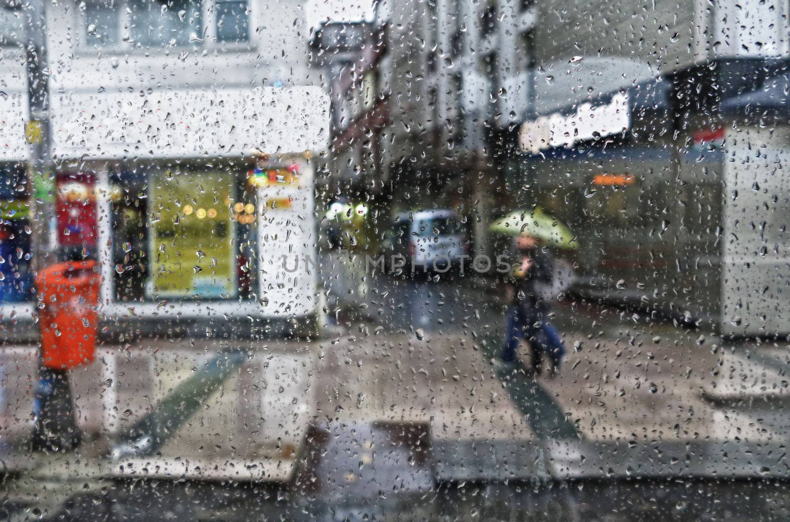 Street scene seen from a parked car during a rain shower.