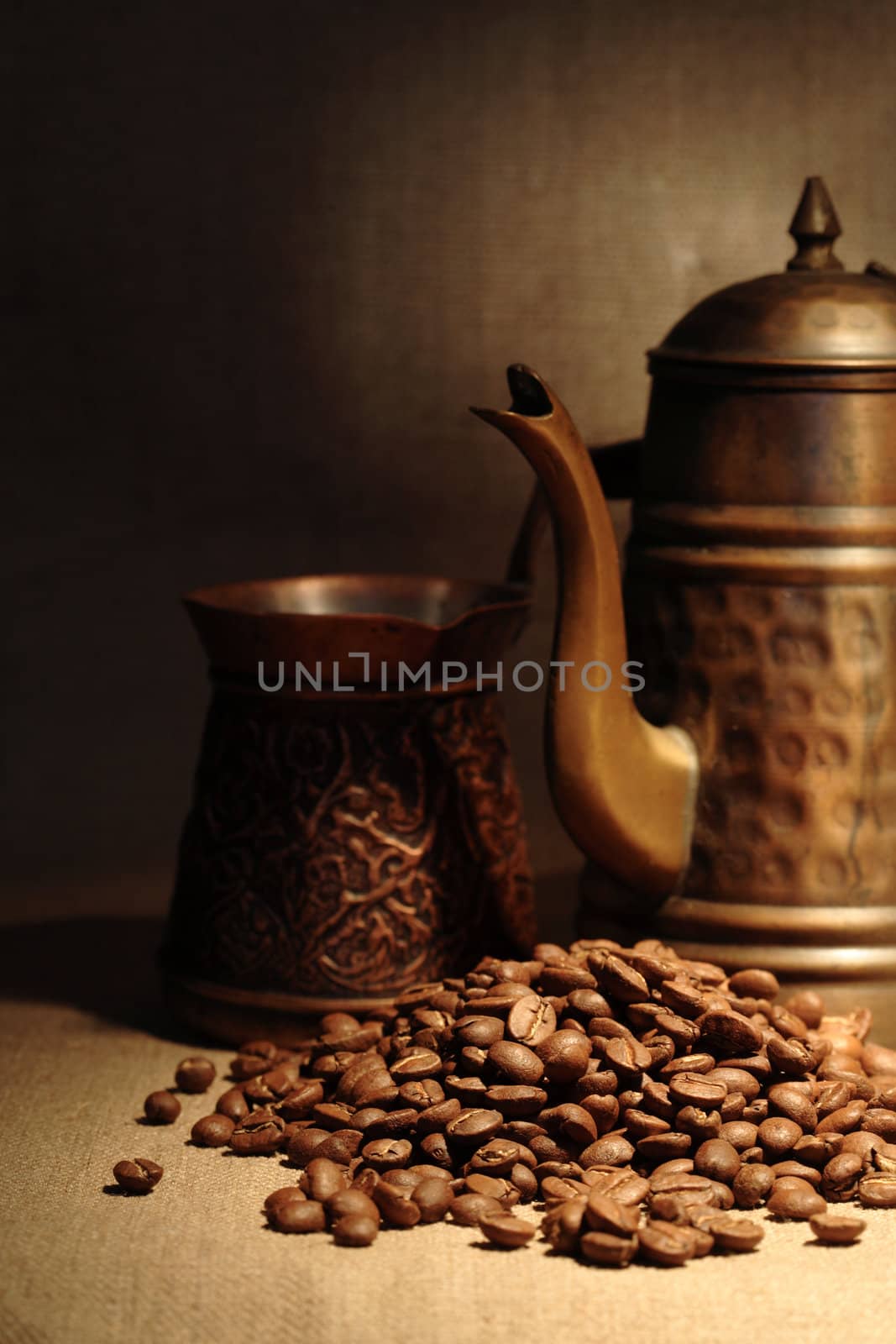 Vintage still life with heap of coffee beans near old copper coffeepot