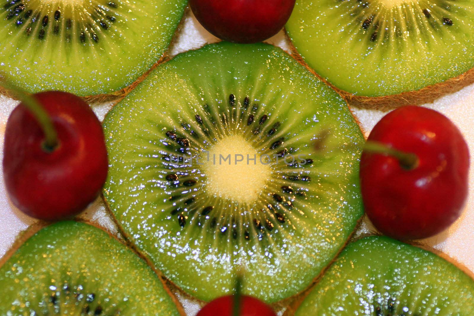 A macro of some kiwi and cherries.
