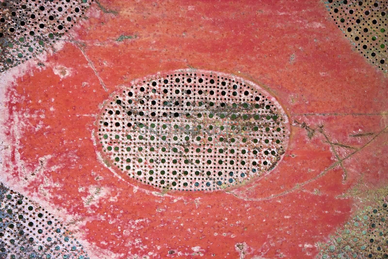 Old red patterned piece of metal.
