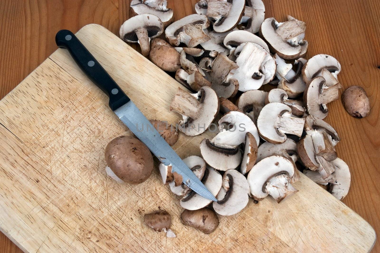 Organic mushrooms being sliced on a chopping board