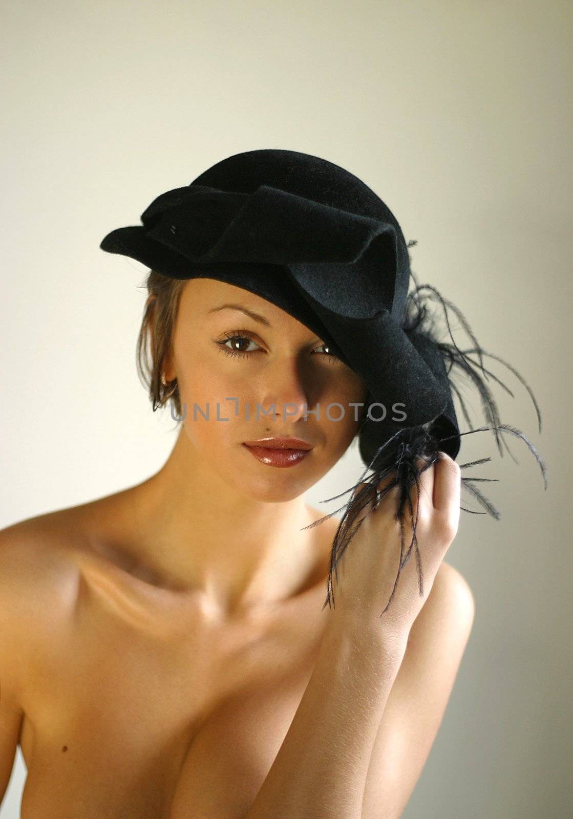 Portrait of the beautiful girl in black to a hat with a bow