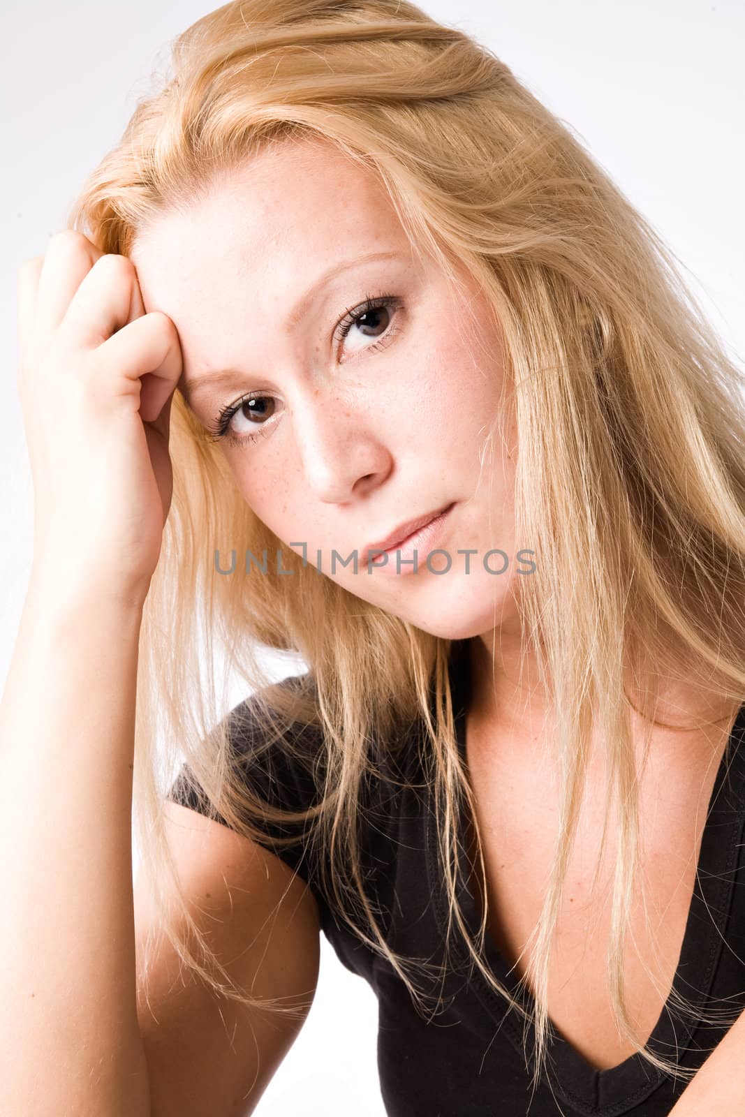 Studio portrait of a young blond girl looking pensive