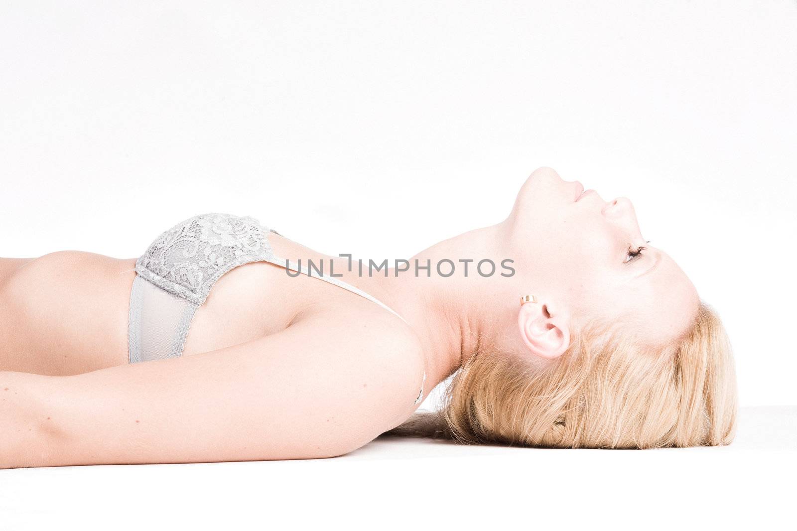 Studio portrait of a young blond girl in bra only posing