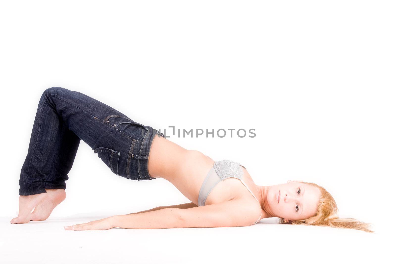 Studio portrait of a young blond girl in bra in a creative pose