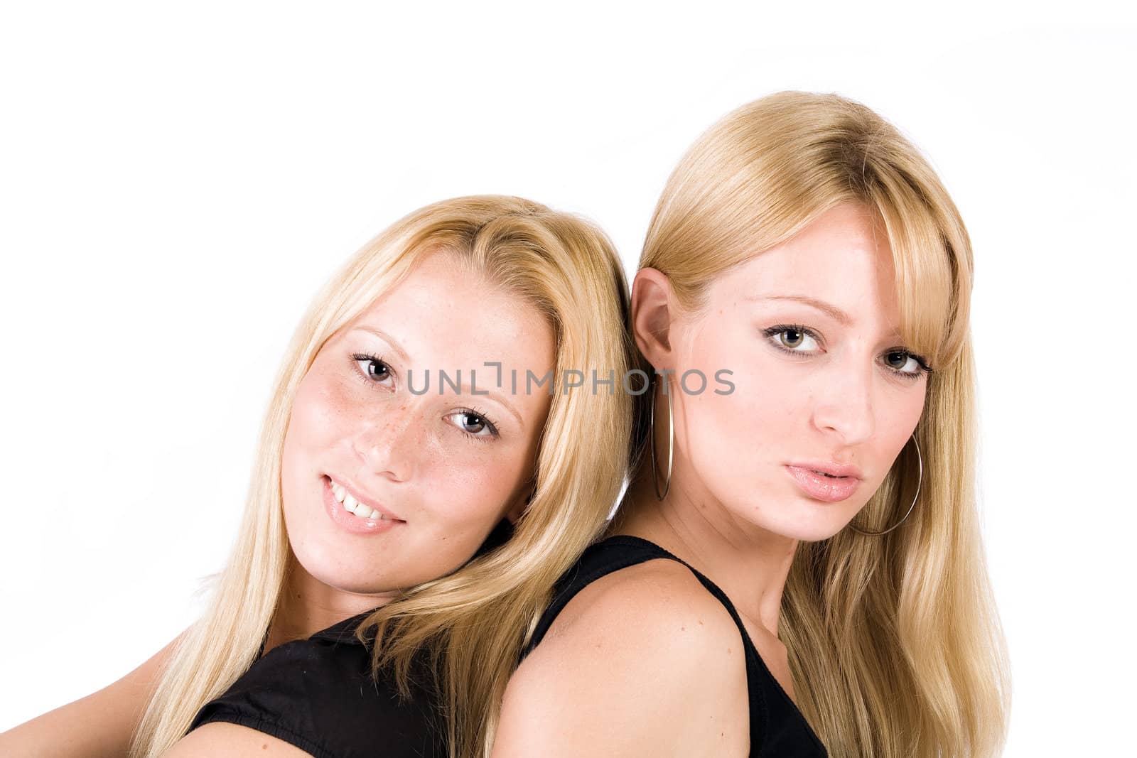 Two blonde women standing back to back