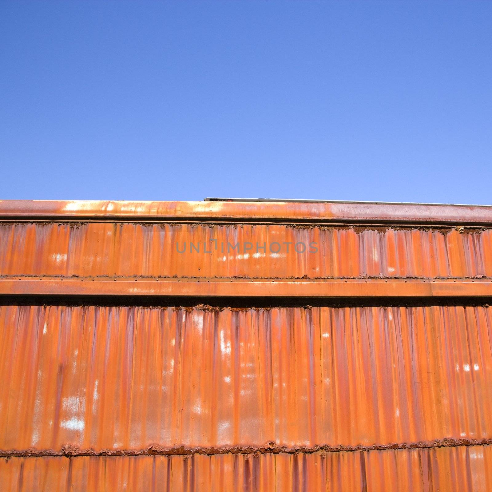 Metal orange siding and blue sky.