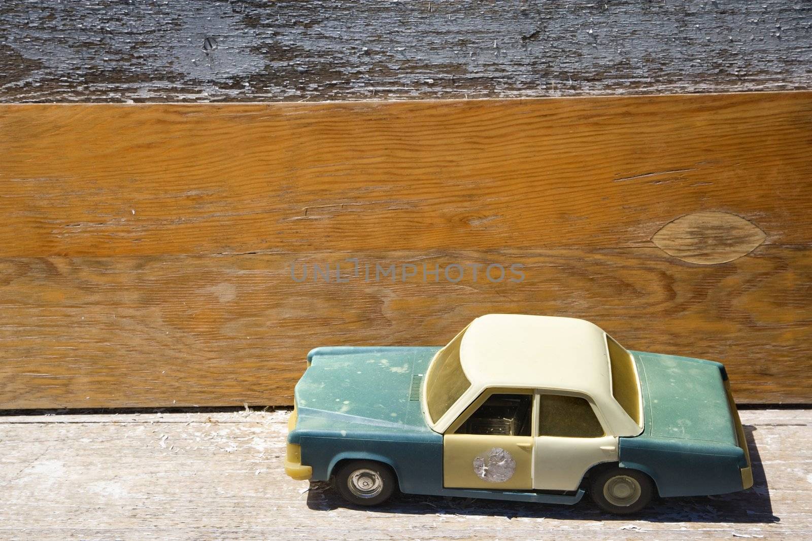 Toy police car on wooden shelf.